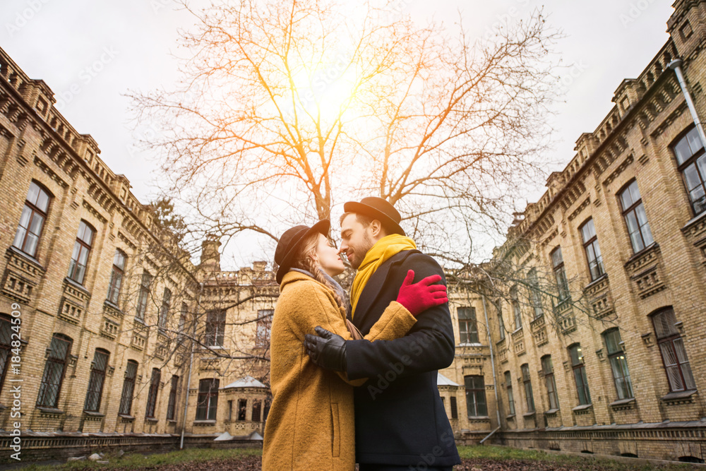 cheerful attractive young couple hugging infront of building