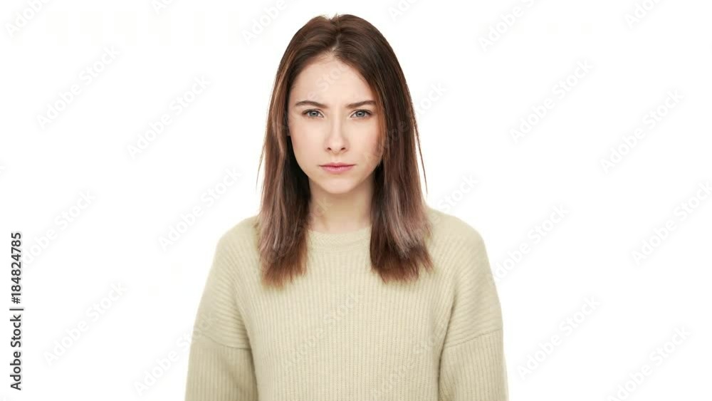 Portrait of serious brunette woman with long hair looking at camera holding index finger on lips asking to keep silence isolated on white background slowmotion. Concept of emotions Portrait of serious brunette woman with long hair looking at camera holding index finger on lips asking to keep silence isolated on white background slowmotion. Concept of emotions