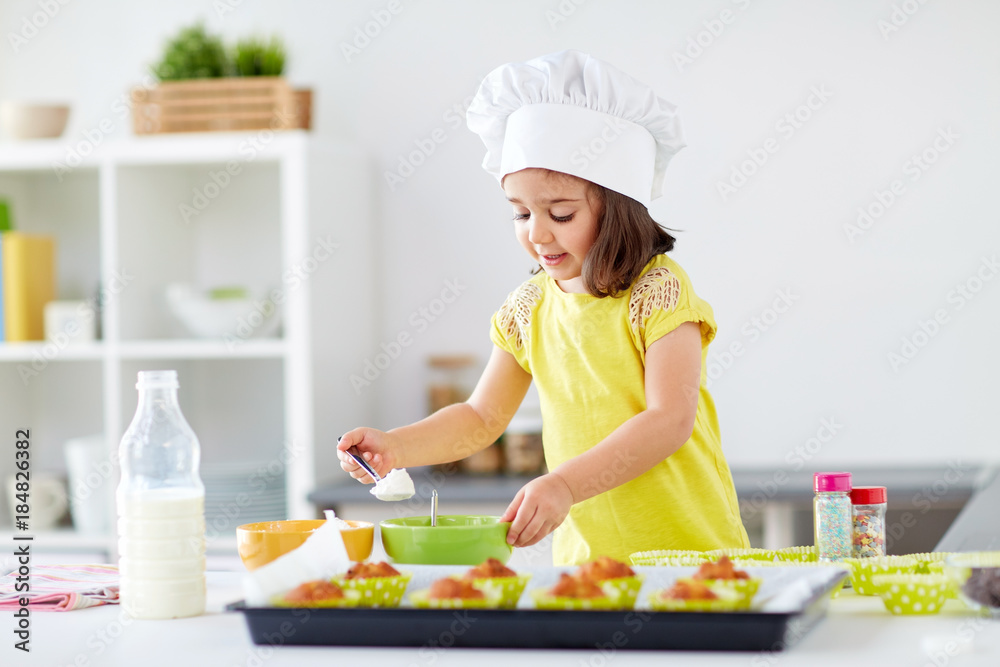 little girl in chefs toque baking muffins at home little girl in chefs toque baking muffins at home