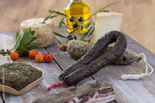 Fototapeta Naklejka Na Ścianę i Meble -  several variety of traditional Corsican charcuterie with an olive branch and black olives on wooden background