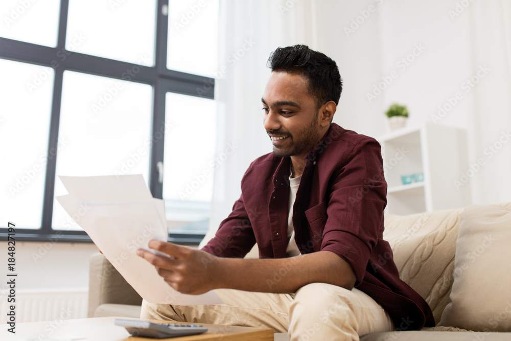 man with papers and calculator at home man with papers and calculator at home