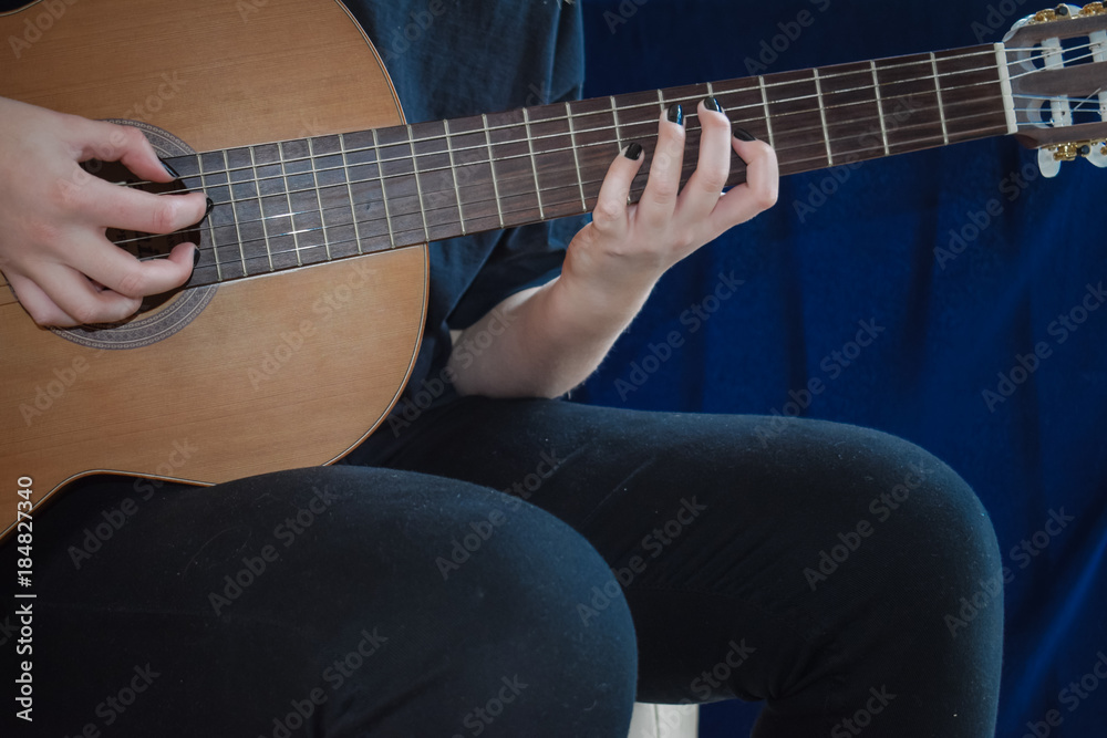 Woman playing music on acoustic guitar