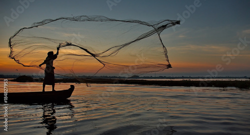 Mandalay. Myanmar. 21 November 2016. Every morning local fishermen catch fish with nets from a boat on lake Taungthaman.