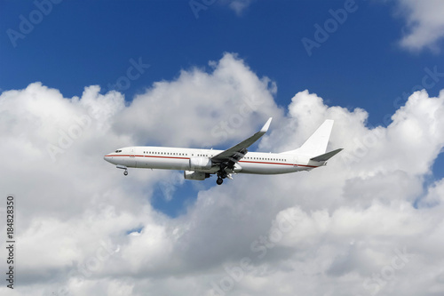 Commercial passenger airplane landing or taking off from the airport with blue cloudy sky in the background