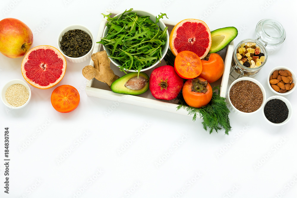 Healthy food in wooden tray: fruits, vegetables, seeds and greens on white background. Flat lay. Top view Healthy food in wooden tray: fruits, vegetables, seeds and greens on white background. Flat lay. Top view