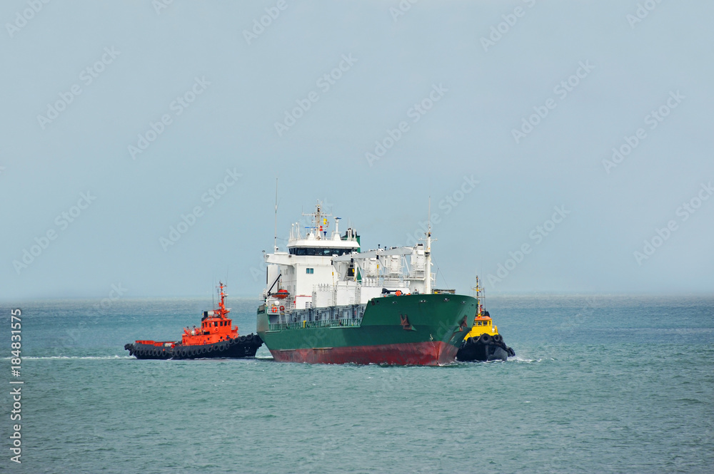 Tugboat assisting refrigerated cargo carrier Tugboat assisting refrigerated cargo carrier