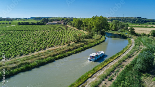 Foto Aerial top view of boat in Canal du Midi from above, family travel by barge and