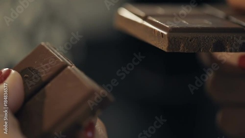Woman breaks chocolate bar. Slow motion photo