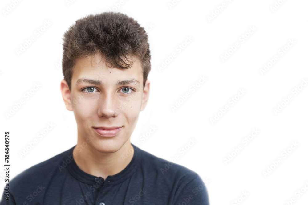 Beautiful teenager on a white background in a blue T-shirt. He smiles. He has a nice face