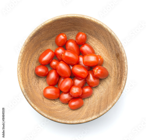 Cherry tomatoes Bobulienka in a wooden bowl isolated on white background top view. photo