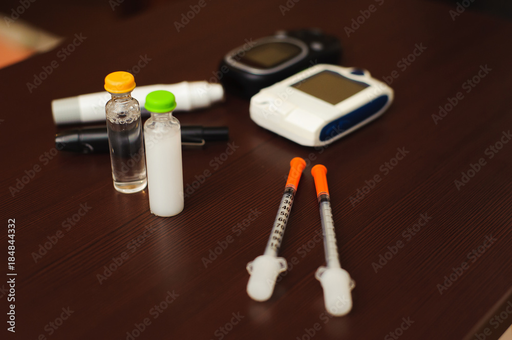 medicine, diabetes and health care concept - close up of blood sugar test stripe, glucometer, insulin pen and other diabetic tools on table medicine, diabetes and health care concept - close up of blood sugar test stripe, glucometer, insulin pen and other diabetic tools on table