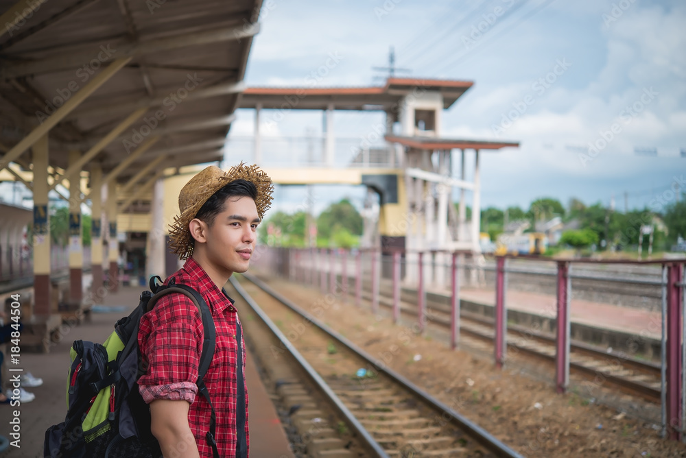 Asian tourist wait train at train station,thailand hipster man go to travel