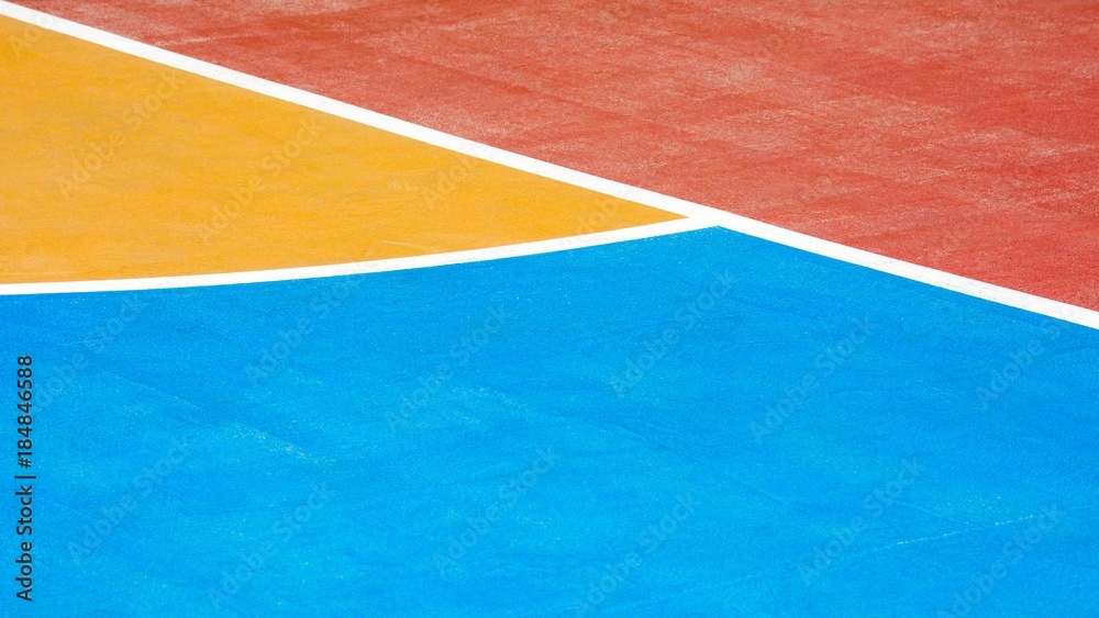red, blue and yellow concrete basketball court - close up
