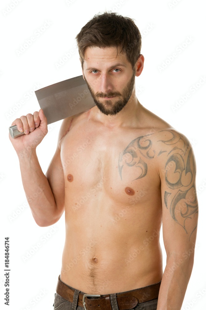 A man with a bandit's beard with a bare torso is holding a big knife in his hands against a white background A man with a bandit's beard with a bare torso is holding a big knife in his hands against a white background
