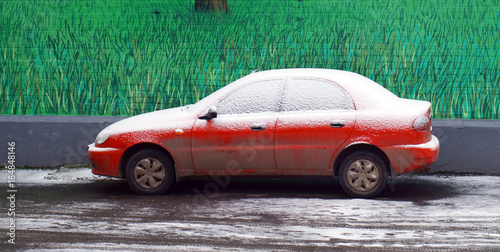 Obraz na płótnie A lonely dirty red car, powdered with snow w salonie