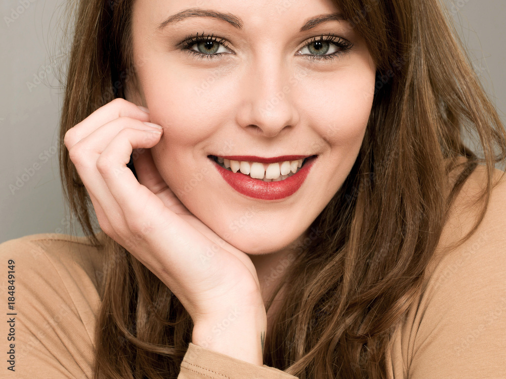 Portrait of a Happy Smiling Young Woman Resting Her Head On Her Hand Looking At The Camera Portrait of a Happy Smiling Young Woman Resting Her Head On Her Hand Looking At The Camera
