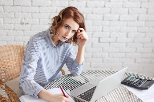 Woman freelancer female hands with pen writing on notebook at home or office photo