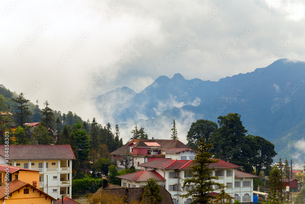 Sa Pa town, landscape mountain range at foggy summer morning Hotels in Sapa, green nature background aerial view.
