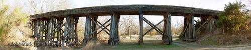 Wood Bridge at Sunset, Sunlight streams under the trestle, wide panorama.