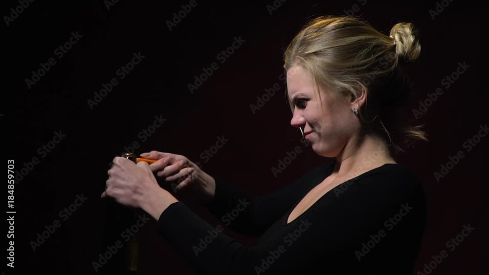 Blonde in a black sweatshirt opens the beer with a lighter, slow motion Blonde in a black sweatshirt opens the beer with a lighter, slow motion