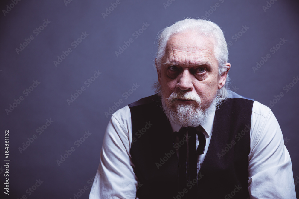 Fototapeta premium Schicker älterer Geschäftsmann sitzt auf Stuhl