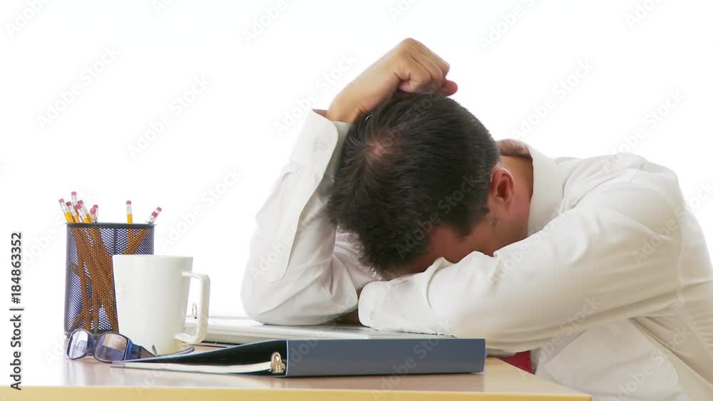 Unhappy businessman putting head on desk Unhappy businessman putting head on desk