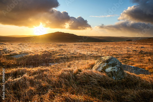 Fototapeta Brown willy tor on bodmin moor at sunrise with beautiful cloudy golden sky, corn
