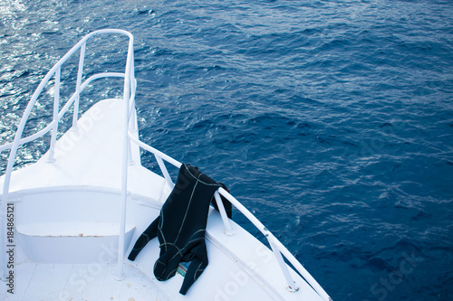 The view of the white yacht and azure sea. wetsuit hanging on the yacht railings. bow of a boat.