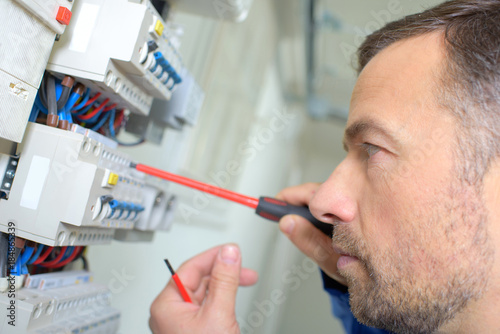 Closeup of electrician working on fusebox