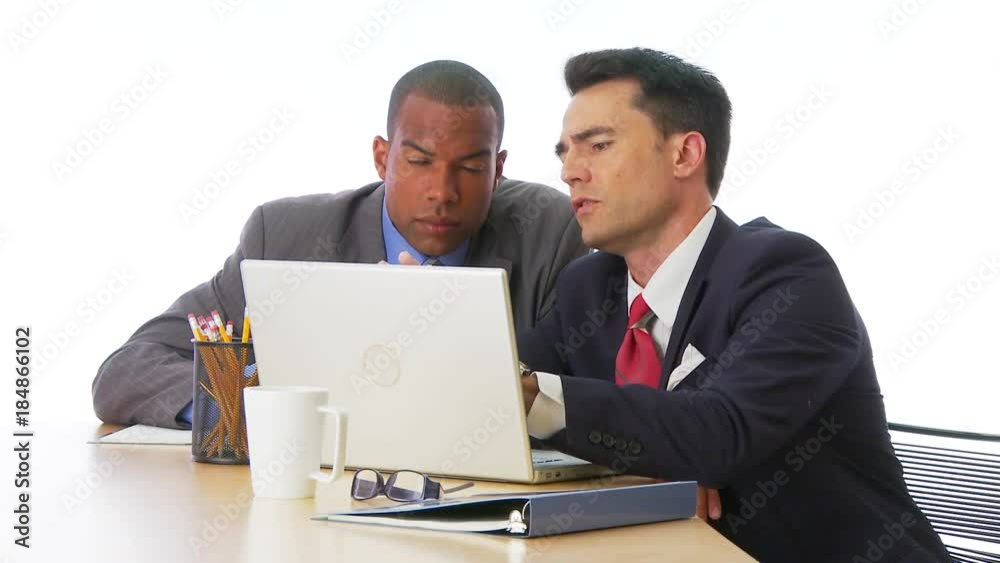 Two businessmen working on computer together Two businessmen working on computer together