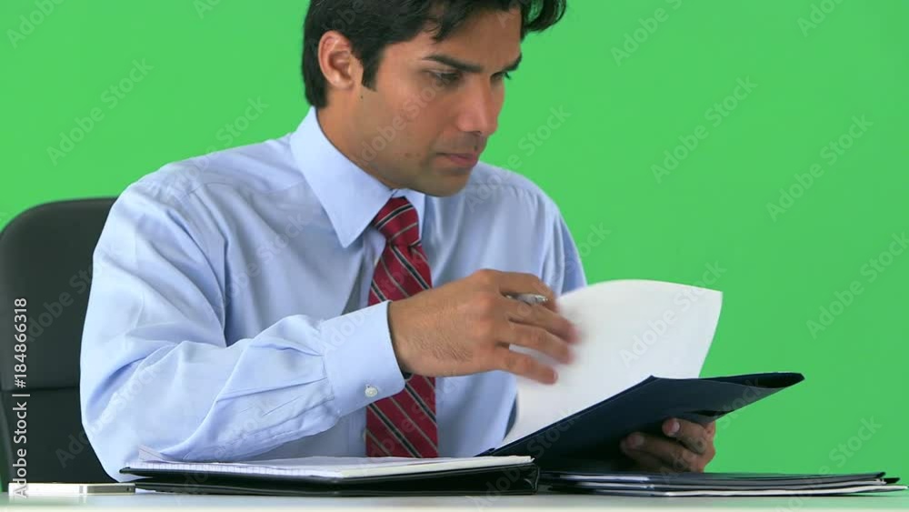 East Indian businessman taking notes on greenscreen East Indian businessman taking notes on greenscreen