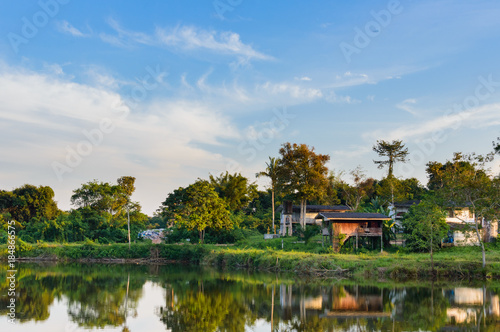 Wooden houses in countryside near the lake with mirror reflection in water