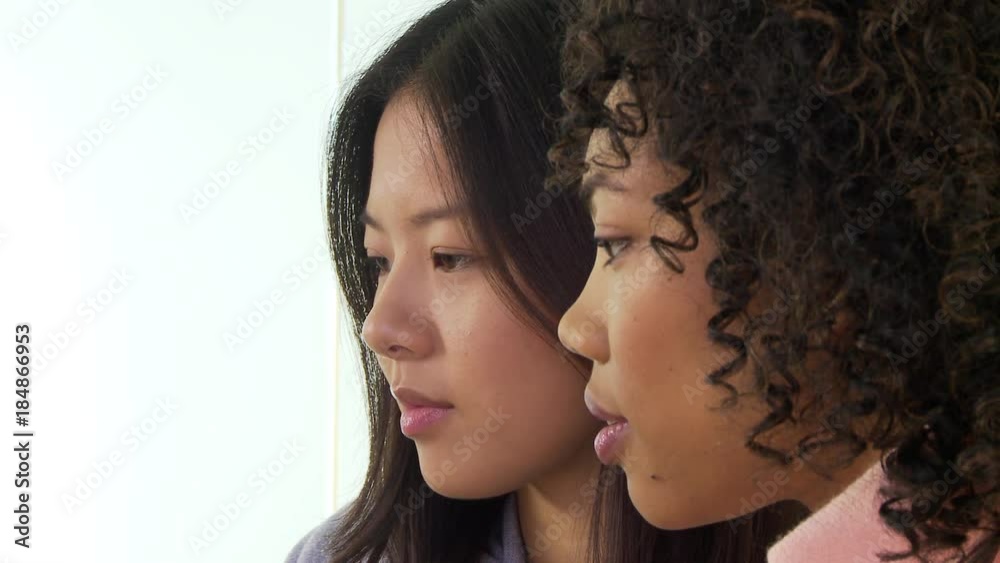 Closeup faces of two young ethnic businesswomen