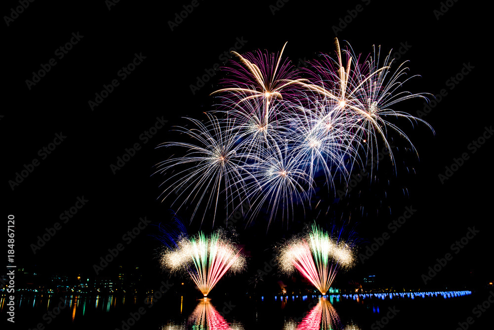 Beautiful fireworks in the night sky on the surface of the water in the park. Beautiful fireworks in the night sky on the surface of the water in the park.