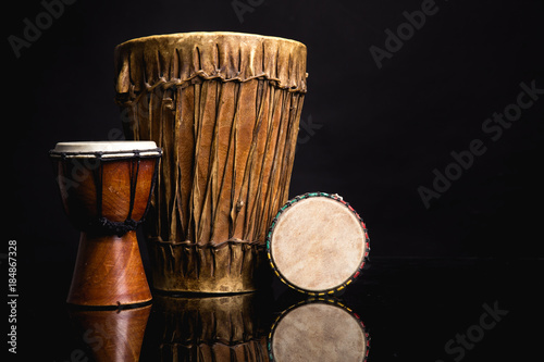 Three old handmade Djembe drums isolated on black