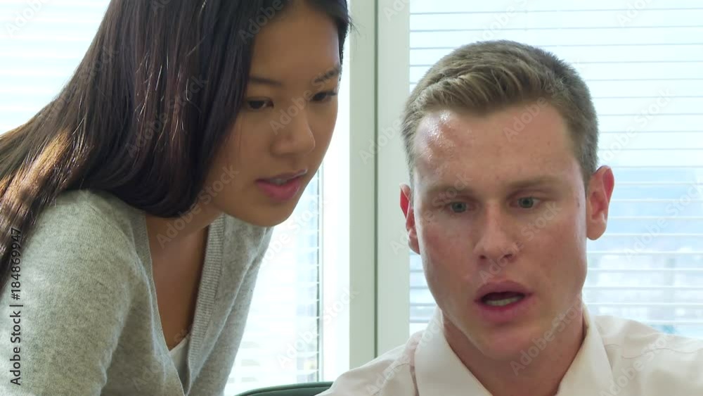 Closeup of young business colleagues discussing work at desk area