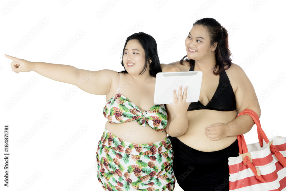 Two fat woman with digital tablet on studio Two fat woman with digital tablet on studio