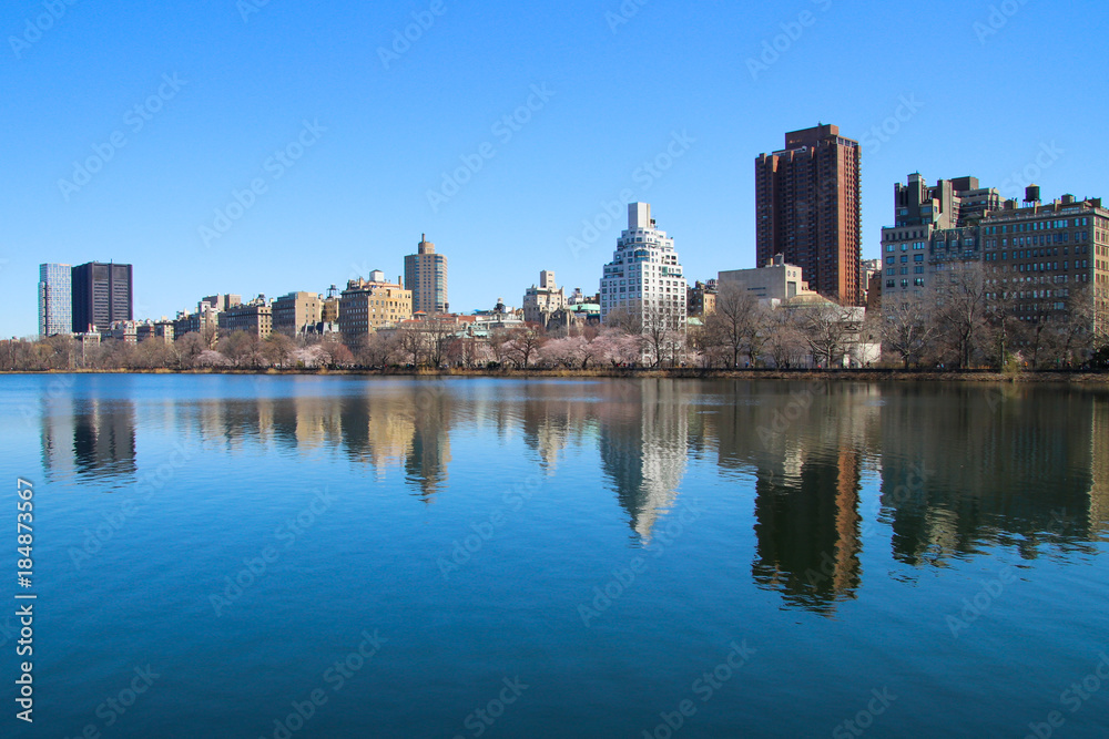 The cityscape with reflection in the water, blue lake and blue sky