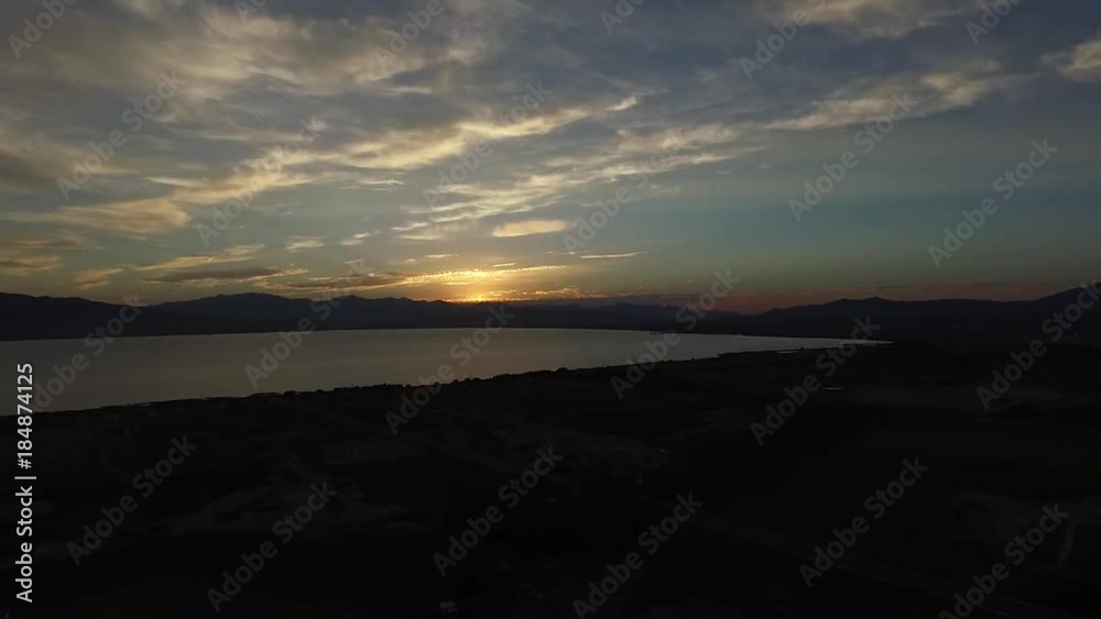 Aerial view of the sunset beyond a lake and mountains Aerial view of the sunset beyond a lake and mountains