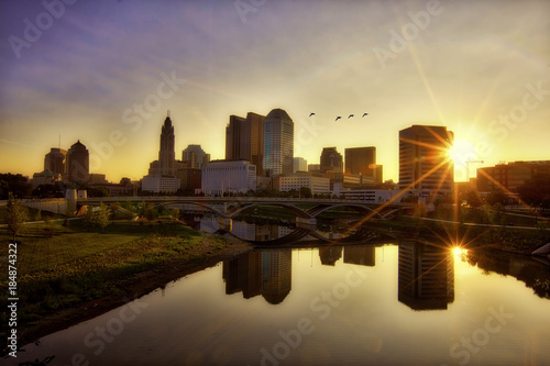 Sunrise along the Scioto river with birds flying over the Columbus, Ohio skyline