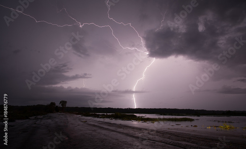 Lightning strike at Fogg Dam, Northern Territory, Australia against a cloudy purple sky