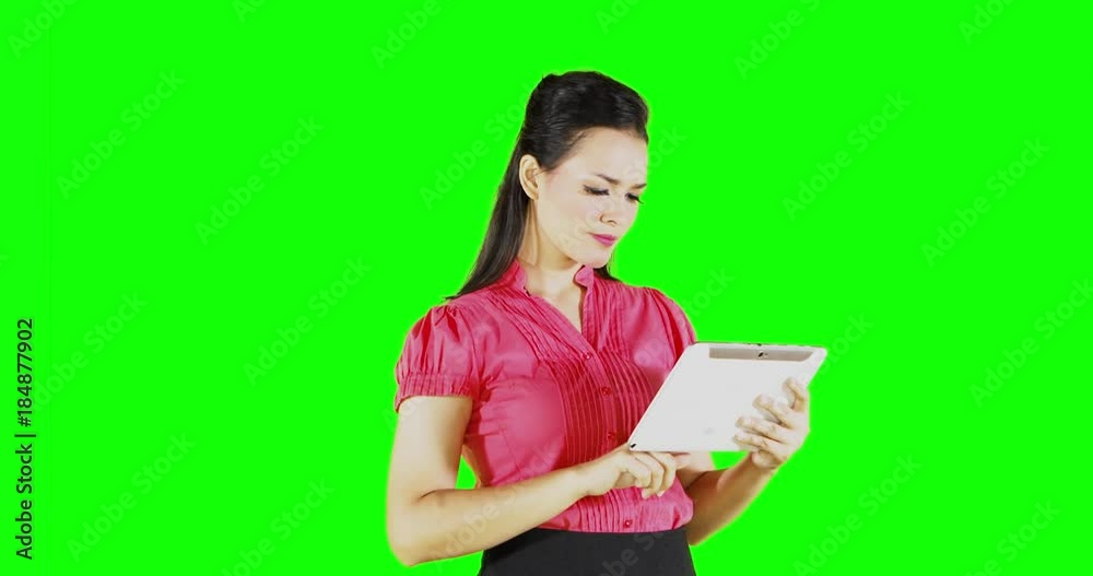 Young businesswoman using a digital tablet computer while standing in front of green screen background, shot in 4k resolution Young businesswoman using a digital tablet computer while standing in front of green screen background, shot in 4k resolution