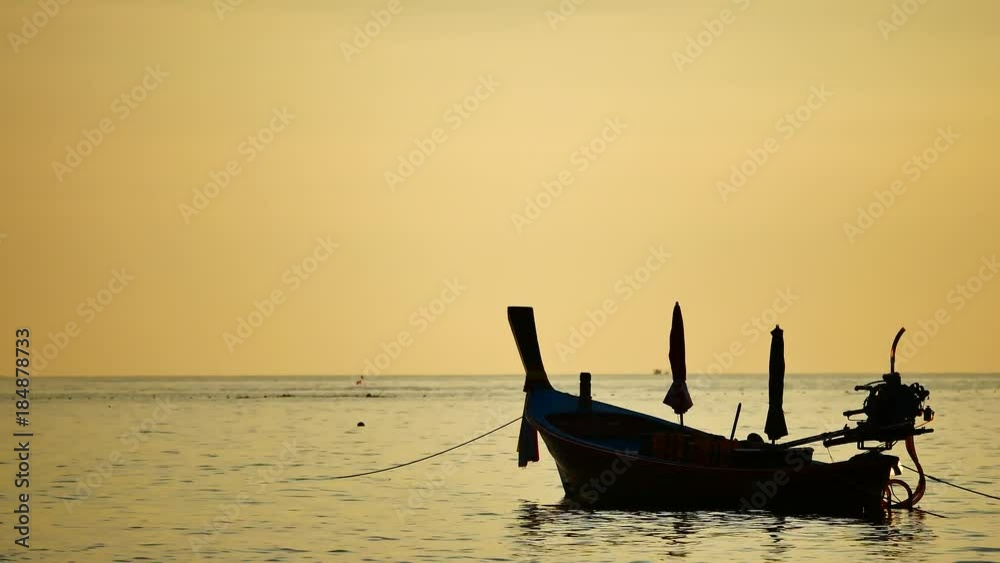 Travel Video silhouette long tail boat converted to boat excursions floating in the andaman sea with golden light of the Sun before sunset in travel or transportation concept. Travel Video silhouette long tail boat converted to boat excursions floating in the andaman sea with golden light of the Sun before sunset in travel or transportation concept.