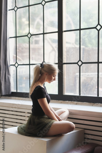 Ballerina sitting near window