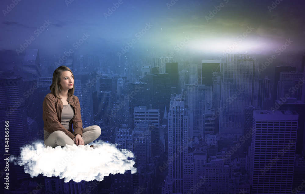 Woman sitting on cloud above the city Woman sitting on cloud above the city