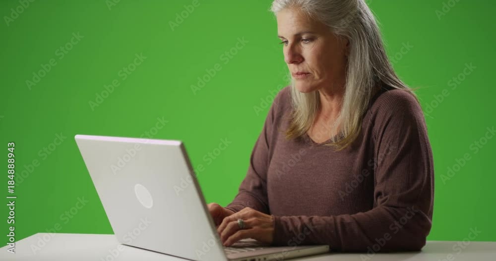 Senior caucasian woman typing on a laptop computer Senior caucasian woman typing on a laptop computer