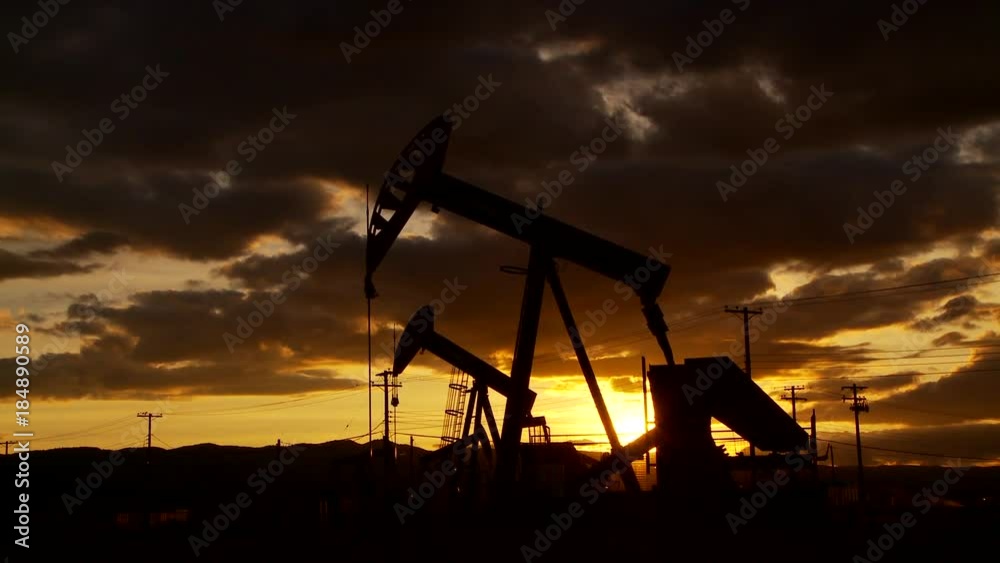 Oil well piston pumps at sunset Oil well piston pumps at sunset