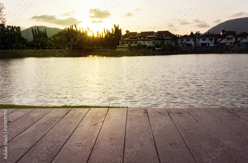 wooden planks from the old wood table, with the lagoon and sunset ,for background and design product. © panya99