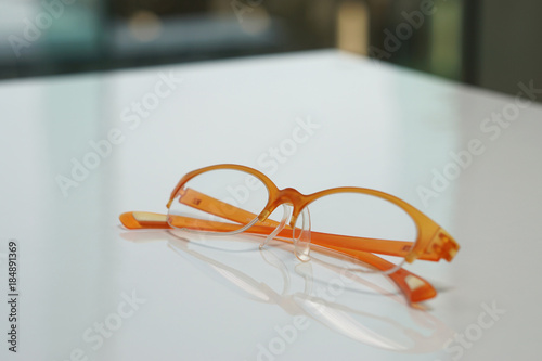 Old orange glasses on white desk