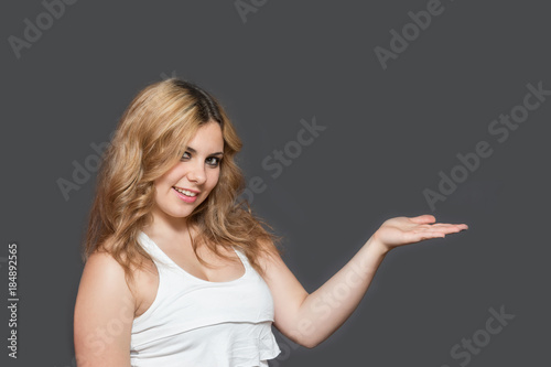 Young woman with outstretched hand smiling at the camera